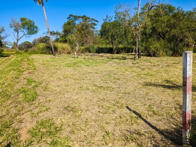 Lot corner marker post with cleared land behind