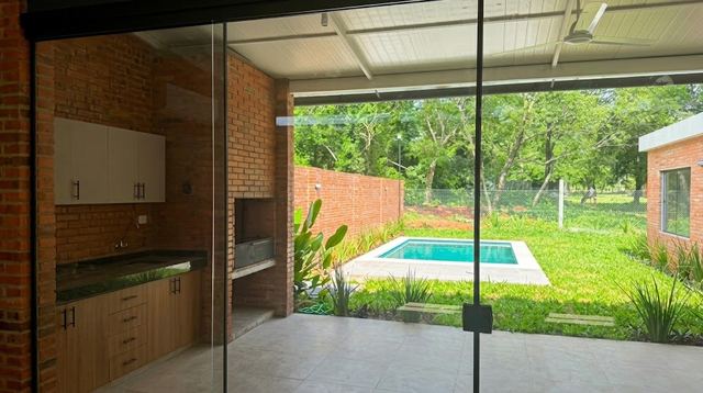 Covered gallery with parrilla looking onto the pool and back garden